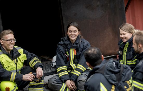 en grupp brandmän sitter tillsammans och pratar