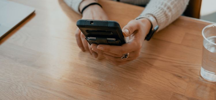 en hand som håller i en mobiltelefon